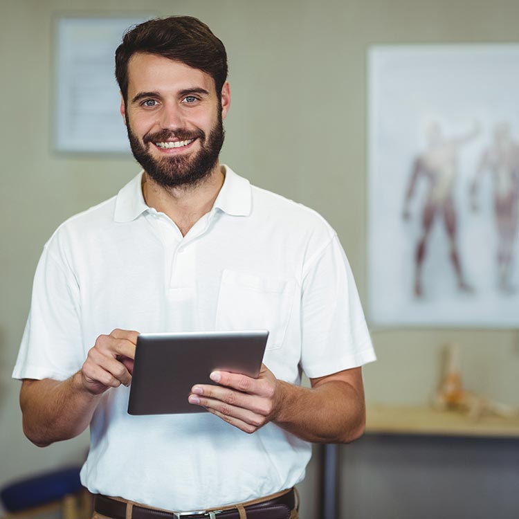 Physical therapist smiling and using CONNECT Rehab EMR software