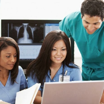 Two women and a man at computer looking at data abstraction software